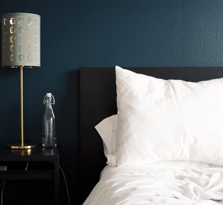 a bedroom, a room where there is a bed, a table with a lamp