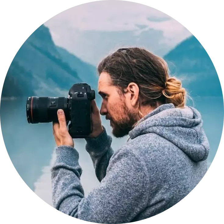 a man with a camera with a gray sweater
