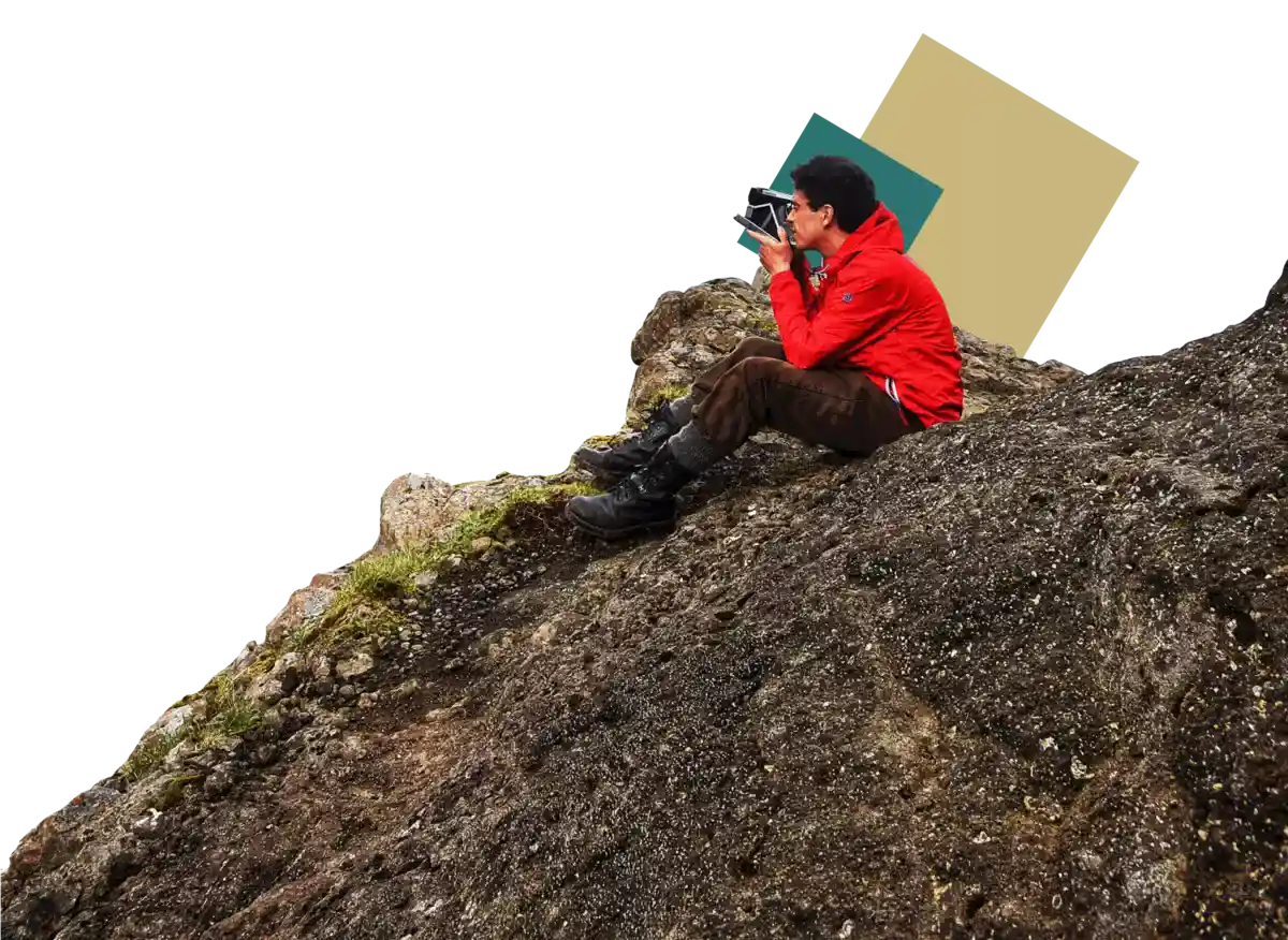 un uomo è seduto sulla montagna con una macchina fotografica