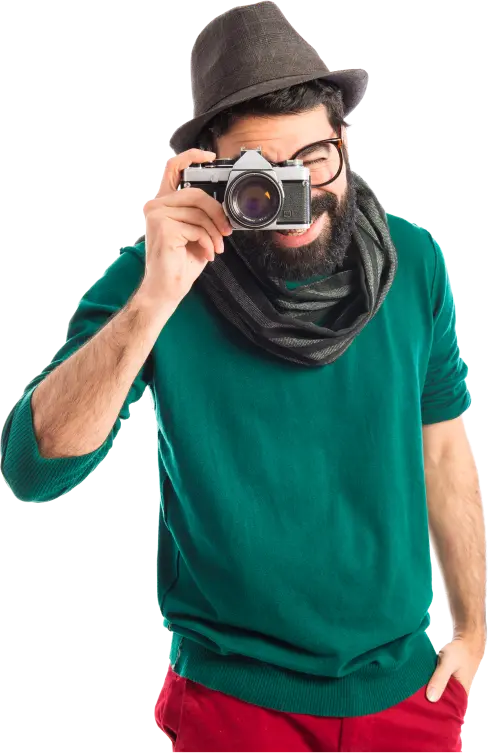 Fotografo con macchina fotografica retrò, cappello e maglione verde