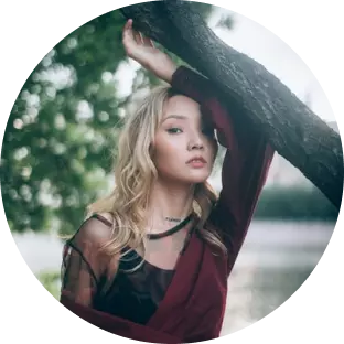 a girl with blond hair by the tree