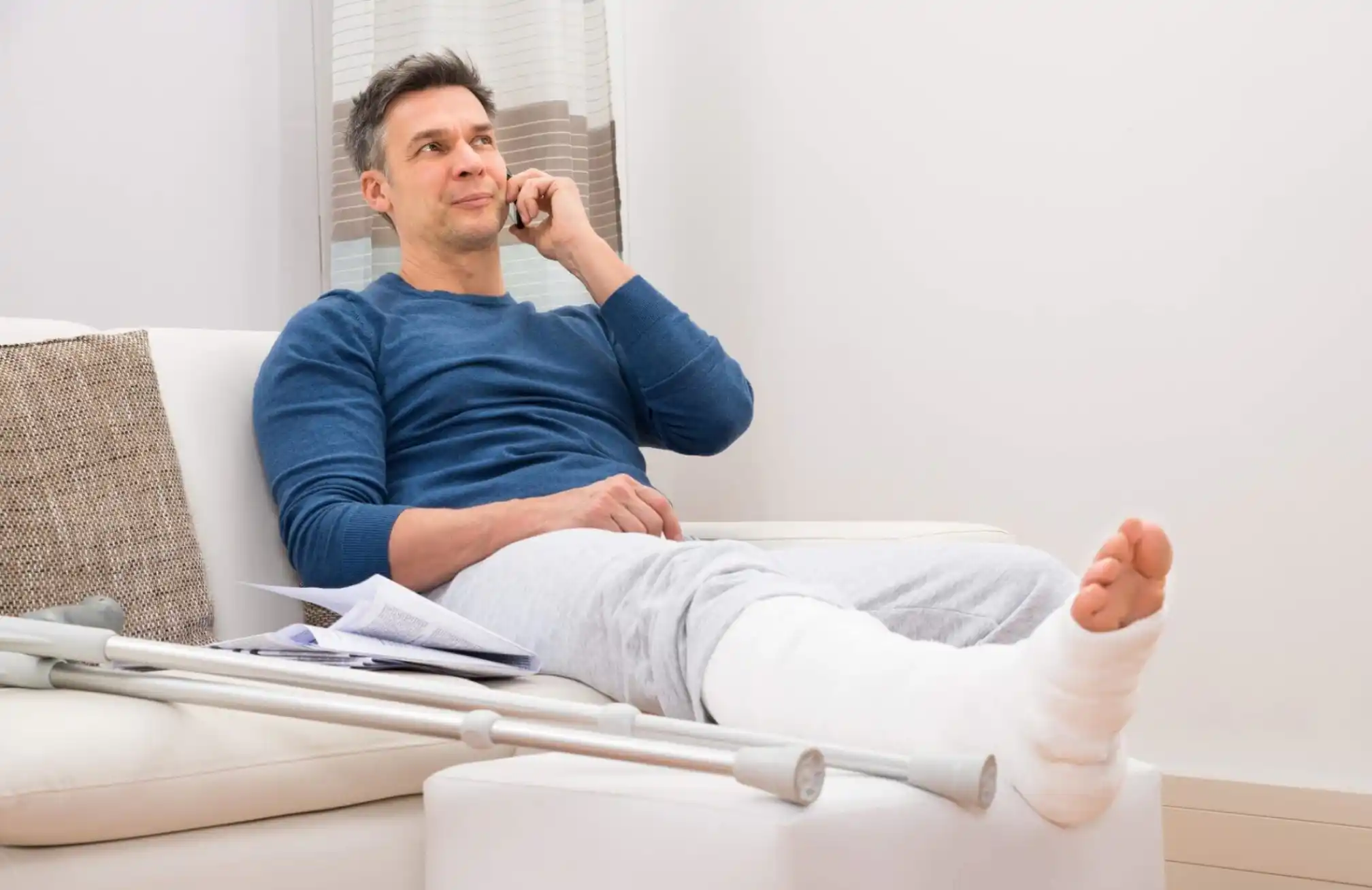 a man is lying on the couch and talking on the phone