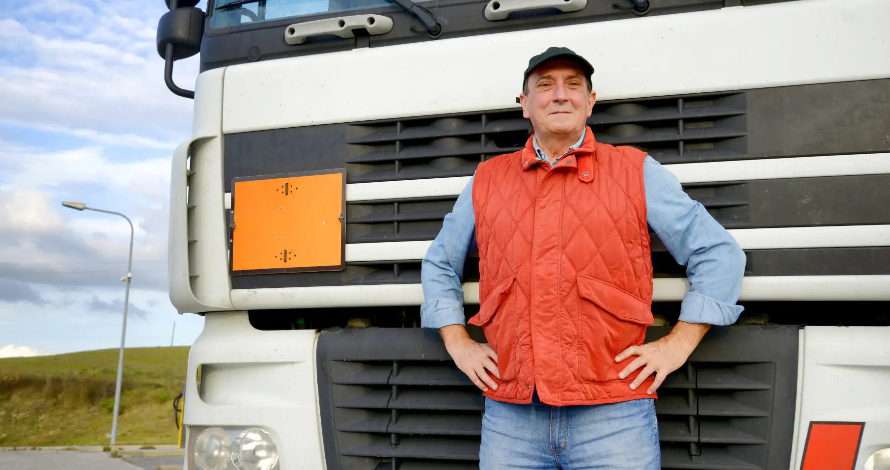 a man in an orange vest is standing near the car