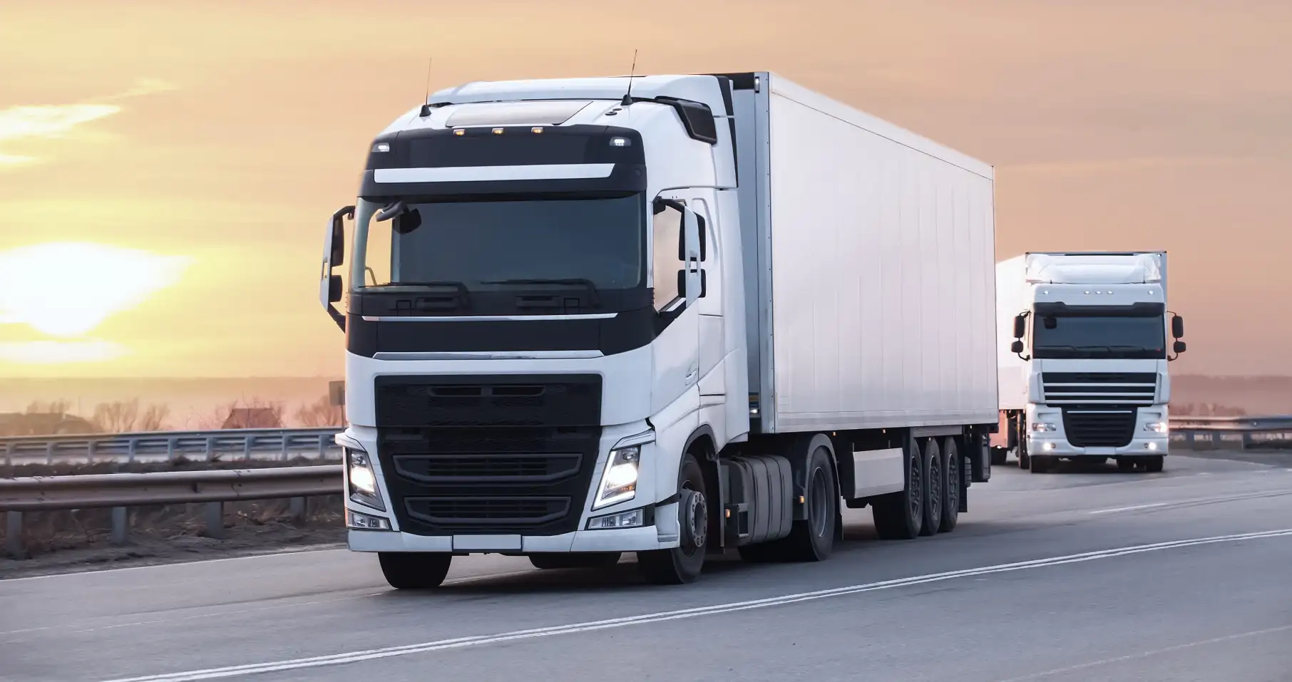 two trucks are driving down the road