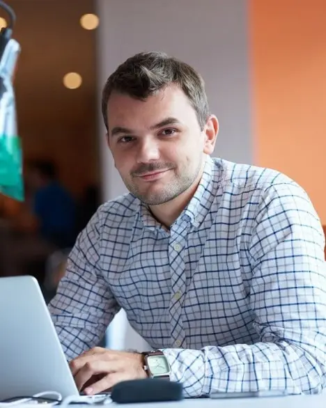 a man in a shirt is working at a laptop