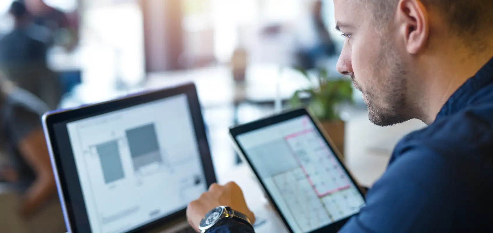 a man with a watch on his hands works at a laptop