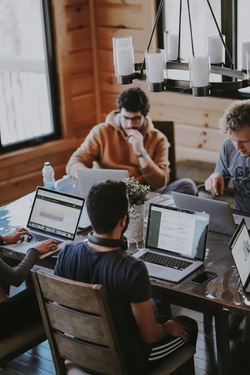 five people looking at a laptop