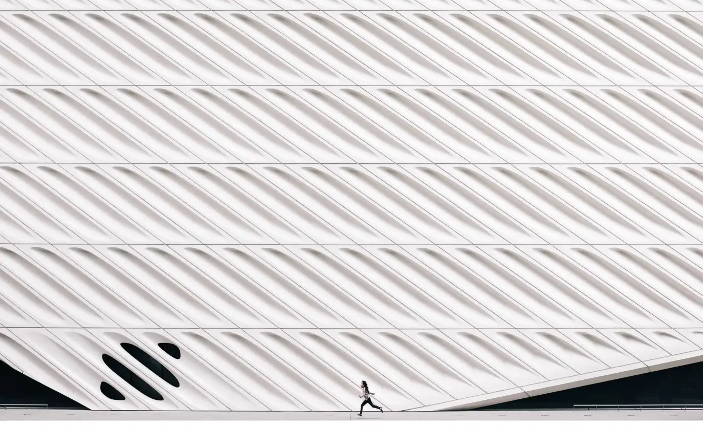 a man runs near the white wall