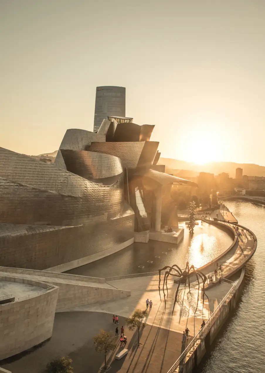 a multi-storey building with fountains by the river