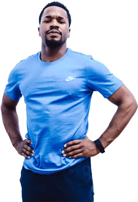 sports trainer with short hair and goatee wearing blue shirt and dark trousers