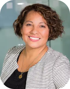 woman with curly hair and striped jacket with a neckles
