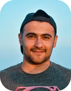 a white man with facial hair and cap hat looking at the sun