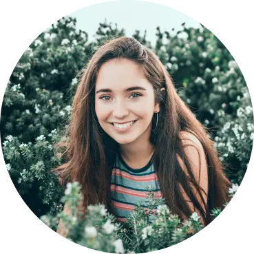 a young woman with brown hair inside rose bushes