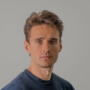 giovane uomo con manica lunga blu navy su sfondo grigio
