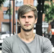 Muž s vousy hledící přímo před sebe