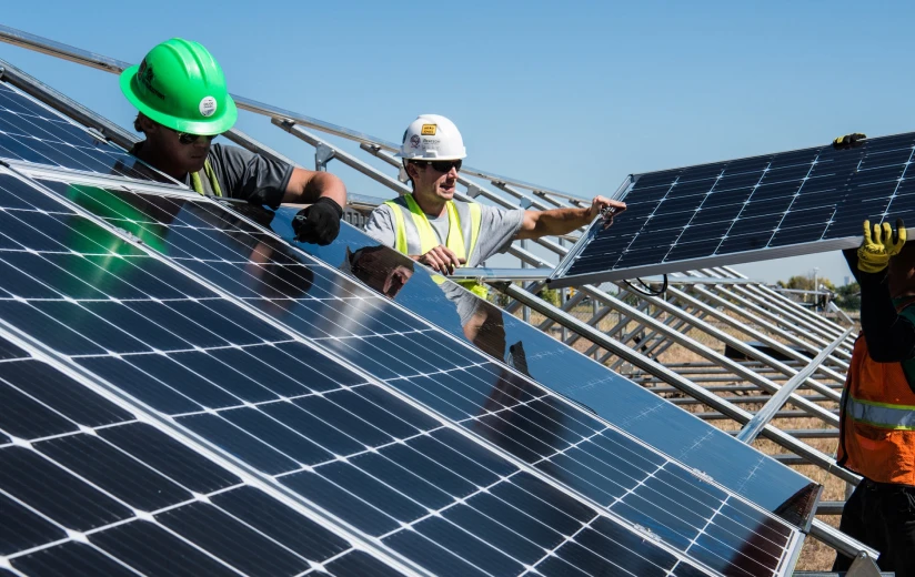 three men install a solar panel