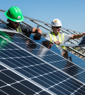 two men near a solar panel