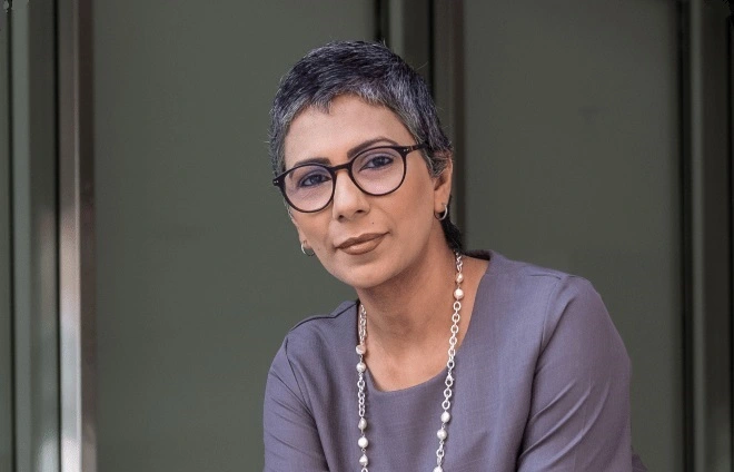 امرأة ترتدي نظارة وفستانًا أرجوانيًا