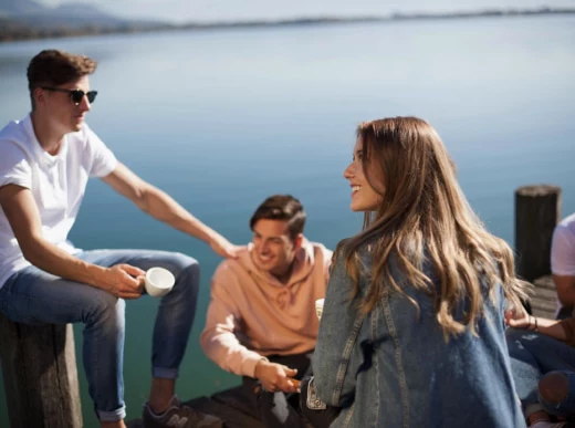 Friends sitting on a pier by the lake