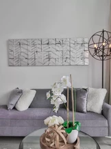 Una moderna sala de estar cuenta con un elegante sofá gris adornado con lujosas almohadas blancas y grises.