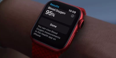A red smartwatch displays a blood oxygen level of 95% on its screen, with a notification message below.