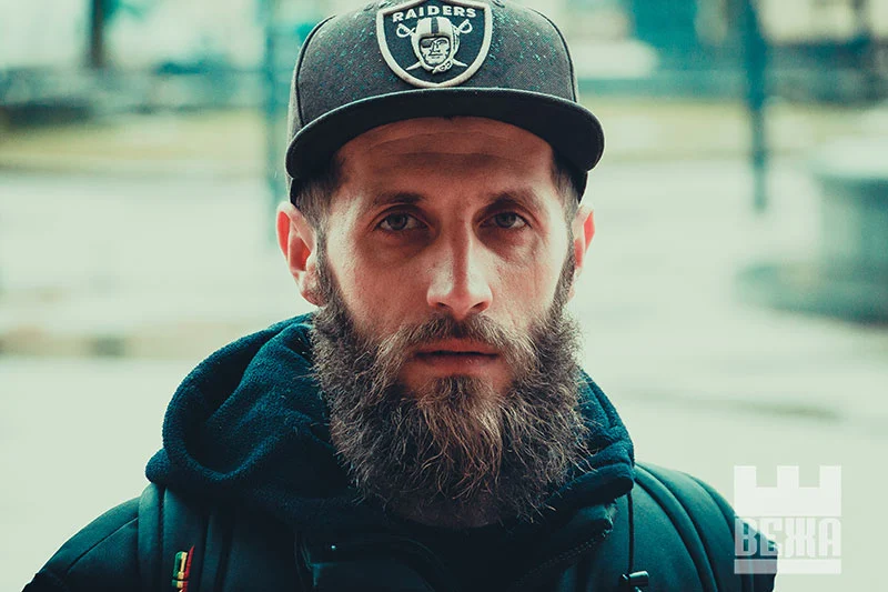 a man with a beard in a cap