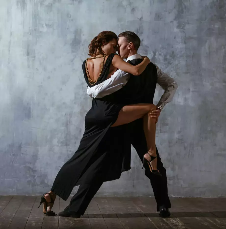 A guy and a girl are dancing salsa