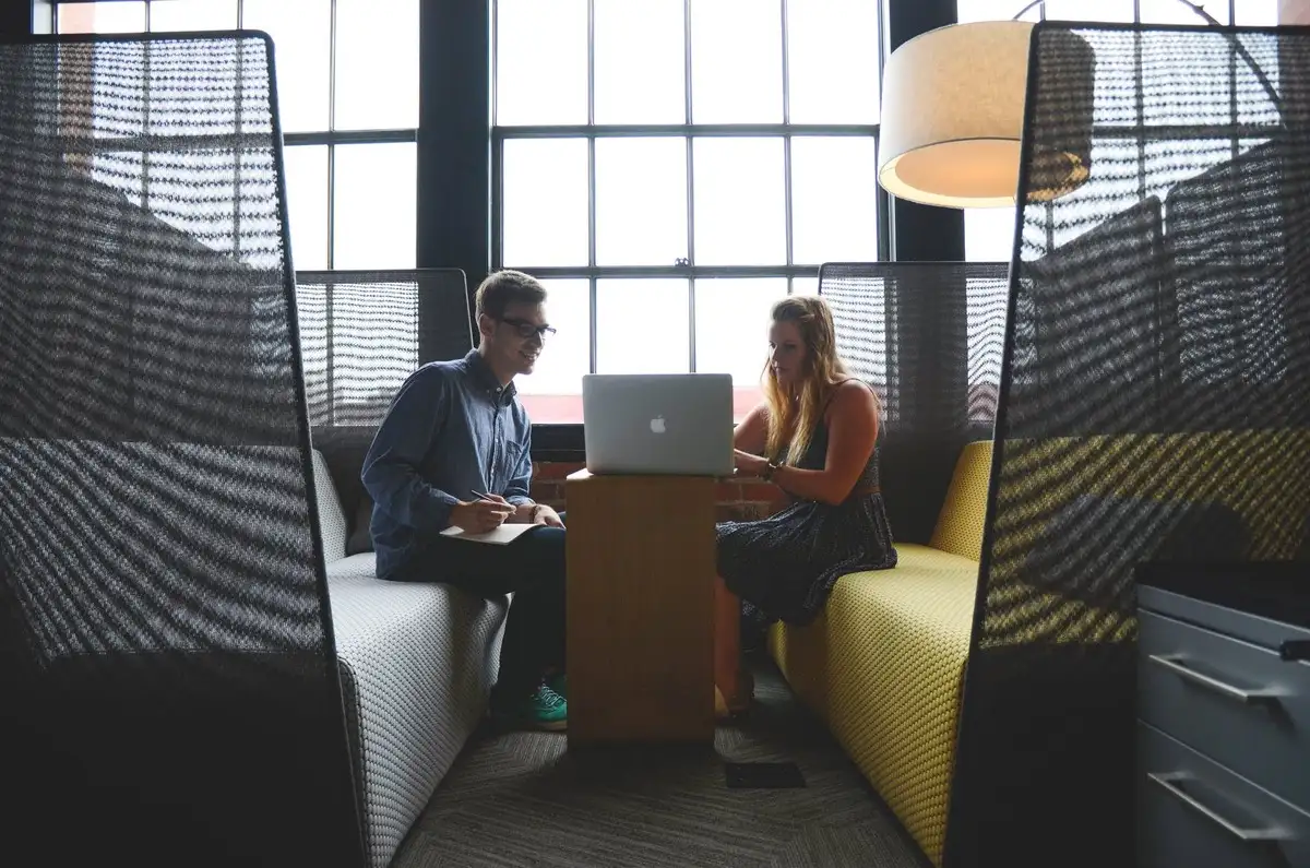 a guy and a girl work at a laptop