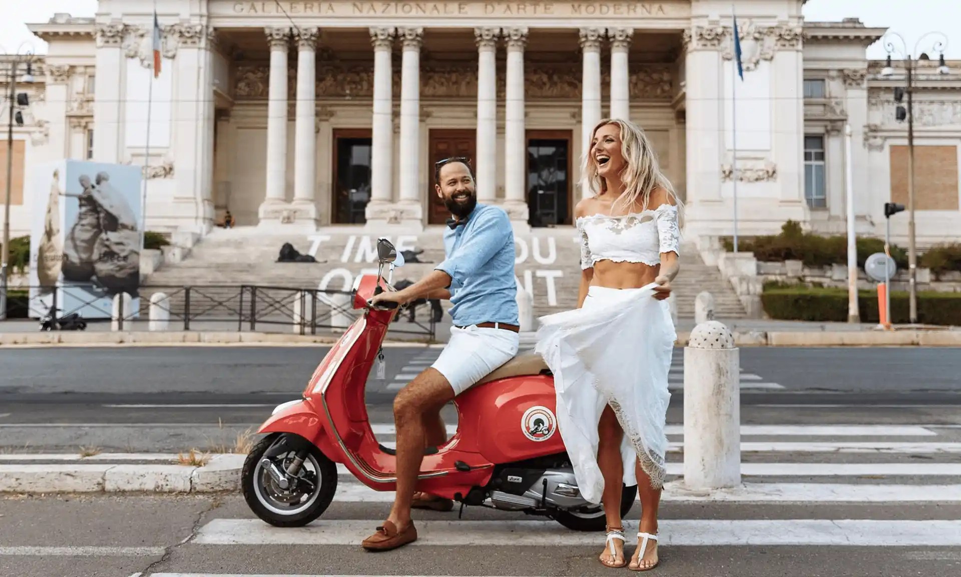 A girl in a white dress smiling and a man next to her