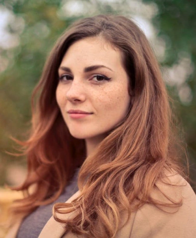 a girl in a brown coat with long hair