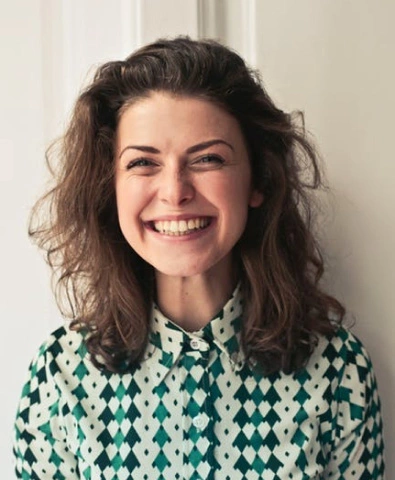 a girl in a colored shirt smiles