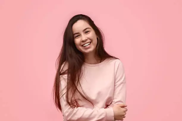 a girl with long hair in a pink dress