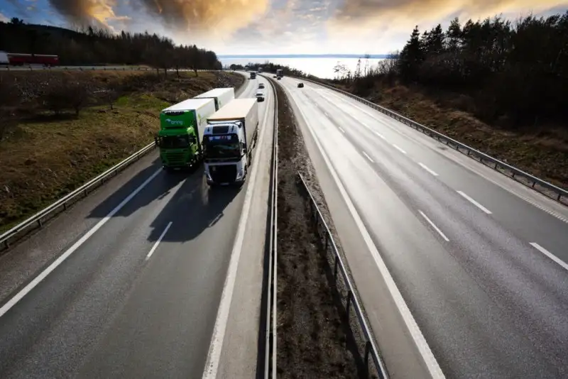 two trucks drive down the road