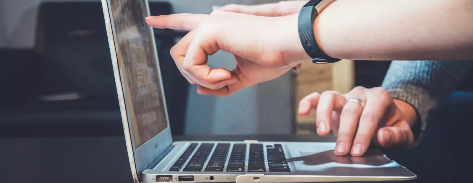 two people work at a laptop