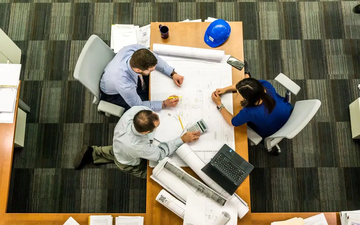 colleagues sit around the table and look at the project