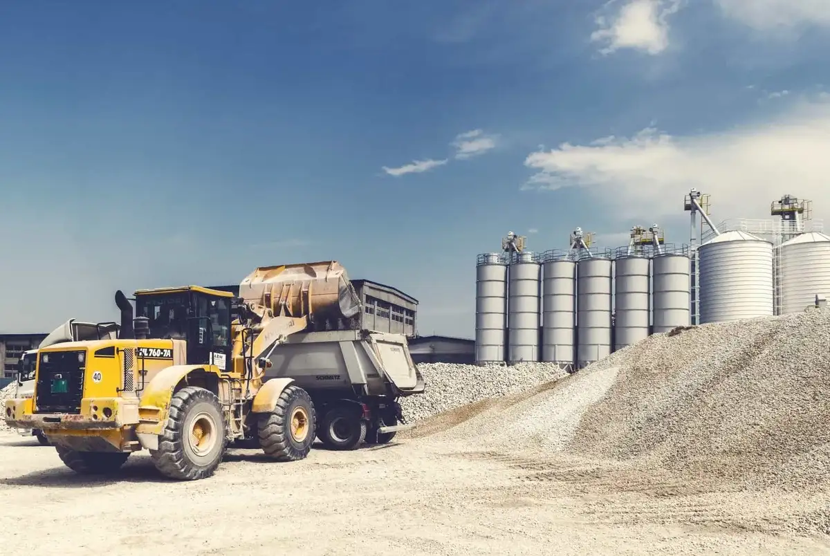 A tractor loads a machine with stone