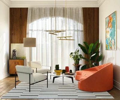 Stilingame svetainėje yra ryškiai oranžinė sofa ir baltas fotelis aplink modernų kavos staliuką ant dryžuoto kilimo.