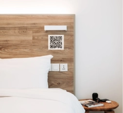 a bedroom with wooden bedrest and a QR code