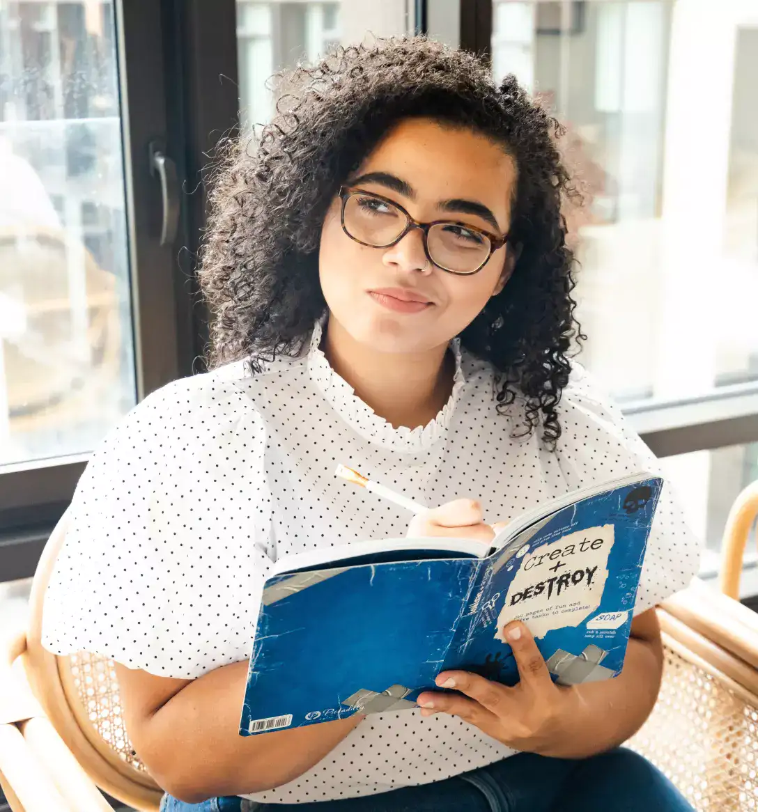 a girl in glasses holds a notebook