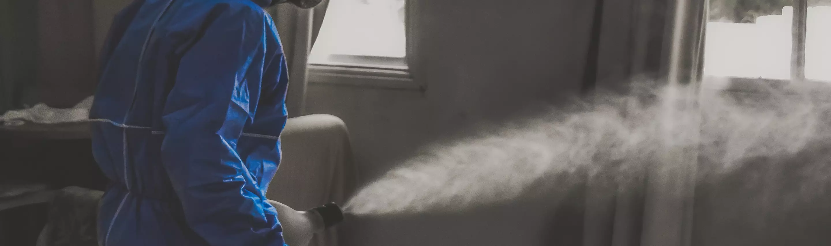 a person in special clothing carries out disinfection