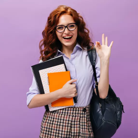 ein Mädchen mit einer Tasche und Notizbüchern in der Hand