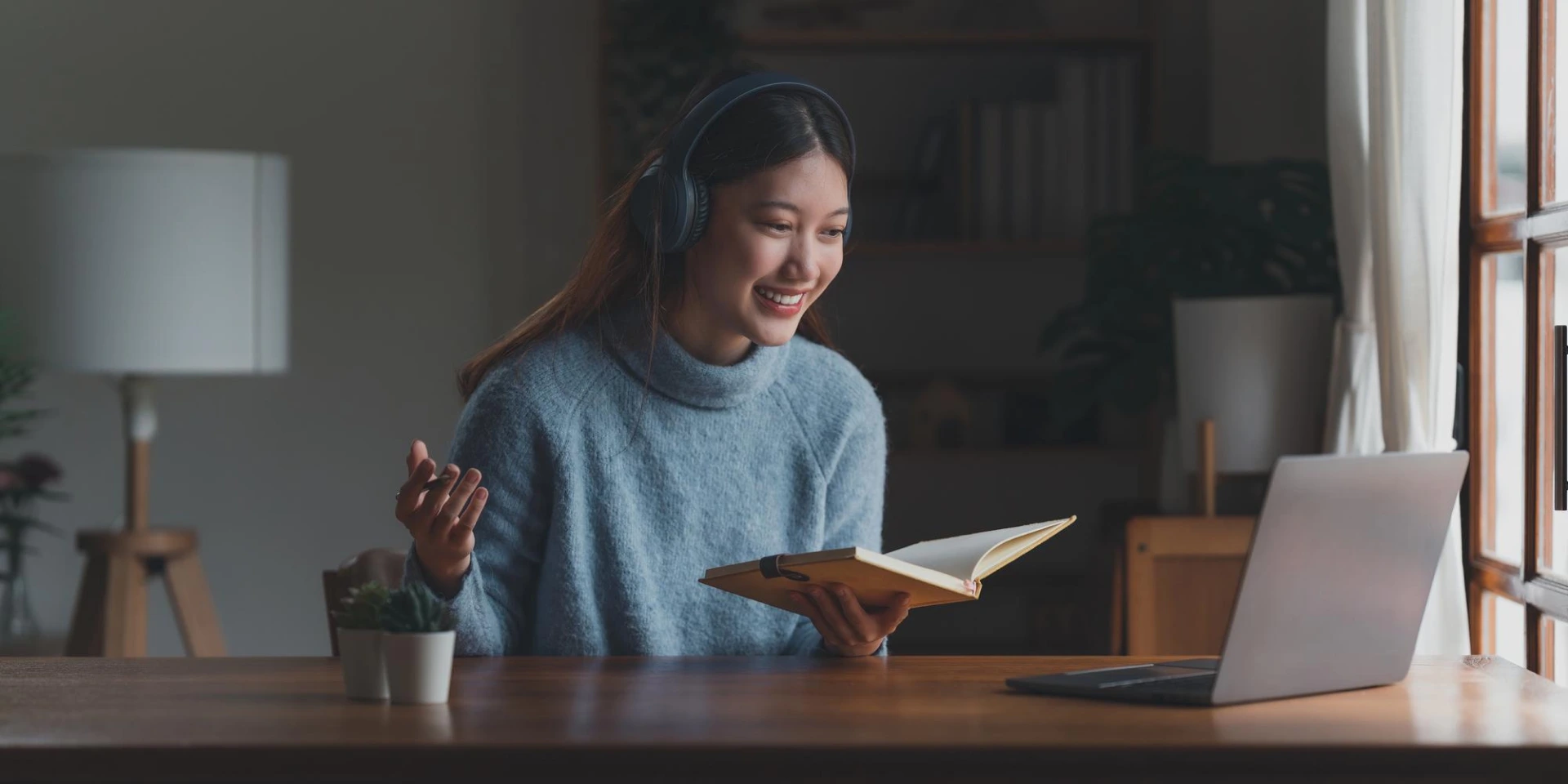 девушка в наушниках держит книгу