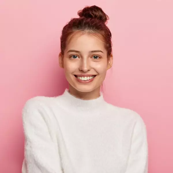 Una chica con un suéter blanco se ríe