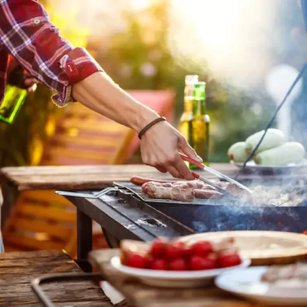 Grilování masa s kořením poblíž na venkovním grilu