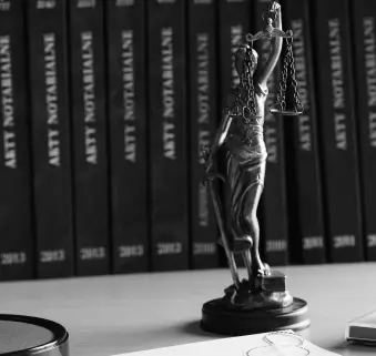 Auf dem Tisch steht eine Statuette einer Frau mit einer Waage in den Händen.