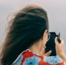 امرأة تلتقط صورة بهاتفها في يوم عاصف