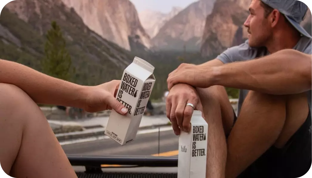 Dos chicos con paquetes de agua en sus manos