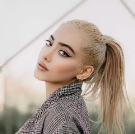 blondynka z lekkim uśmiechem patrząca w kamerę