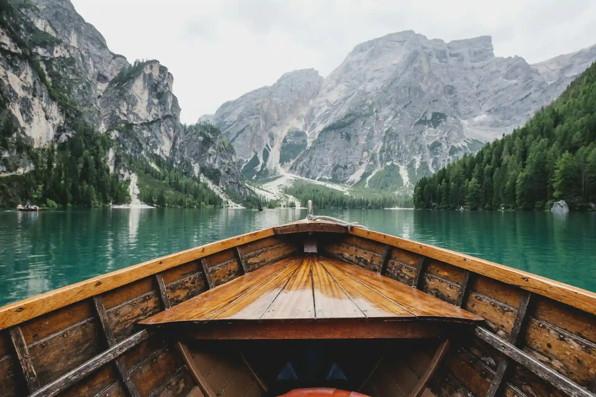 Barco en un lago con agua verde sobre el fondo de las montañas
