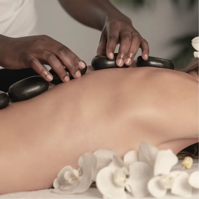 warm stones lie on a woman's back